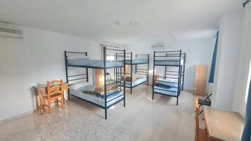 Un dormitorio con literas, un escritorio y una silla.