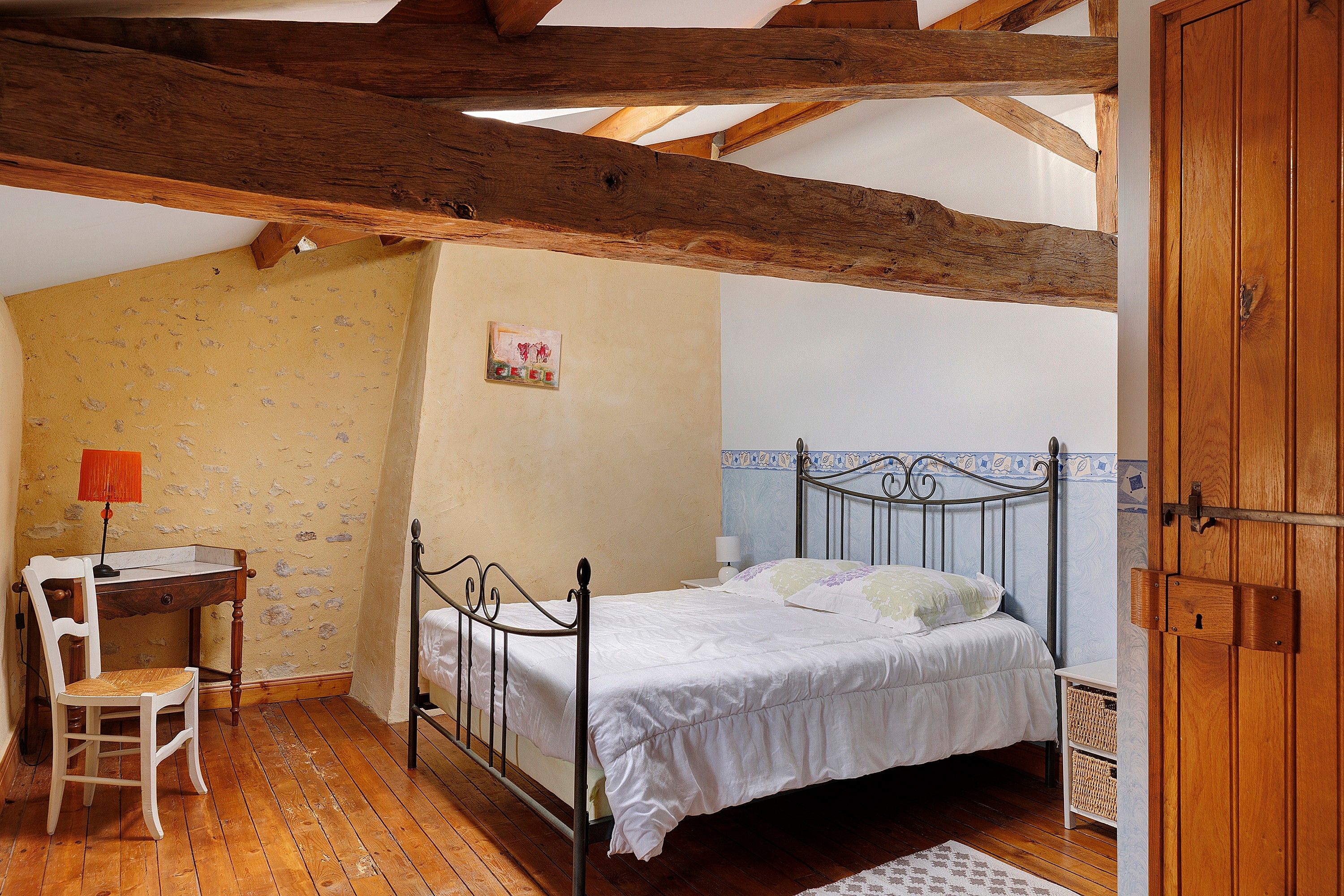 Une chambre avec un lit simple, un bureau et une chaise.