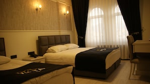 A hotel room with two beds, a desk, and a chair.