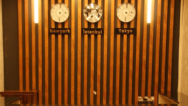 A reception area with clocks indicating New York, Istanbul, and Tokyo times, and the word 'VISTA' illuminated on the floor.