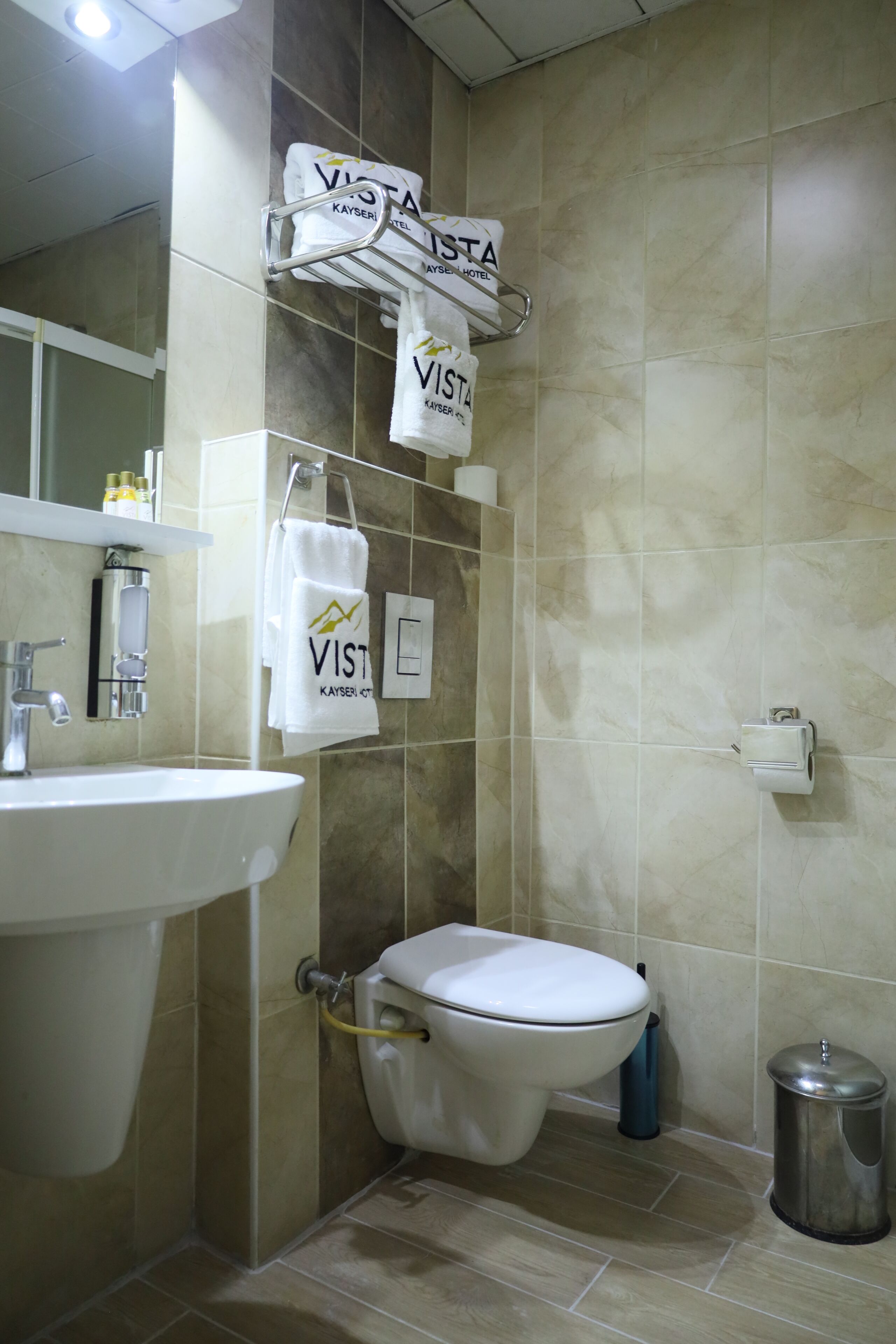 Une salle de bain équipée d’un lavabo, de toilettes et d’un porte-serviettes avec plusieurs serviettes.
