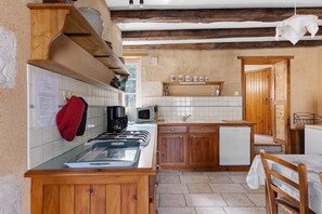 Une cuisine avec des meubles de rangement en bois, une cuisinière, un four à micro-ondes et un évier.