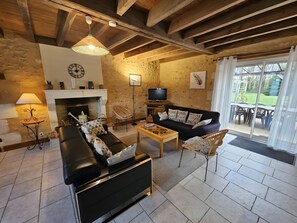 Ein gemütliches Wohnzimmer mit Kamin, einer Couch, einem Couchtisch und einem Fernseher.