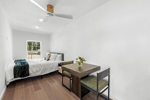 A bedroom with a bed, bedside table, chair, and a ceiling fan. - Modern Farmhouse Cargo Home Retreat with Pool & Goats near Houston in Hempstead, Texas (Hempstead)