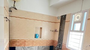 A bathroom with a toilet, shower, and sink.