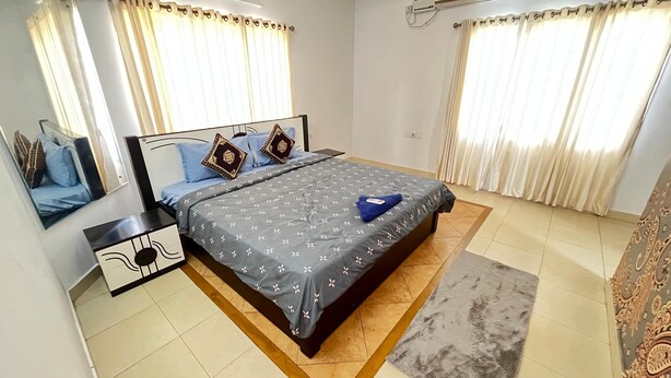 A neatly arranged bedroom with a bed, nightstands, and a rug.