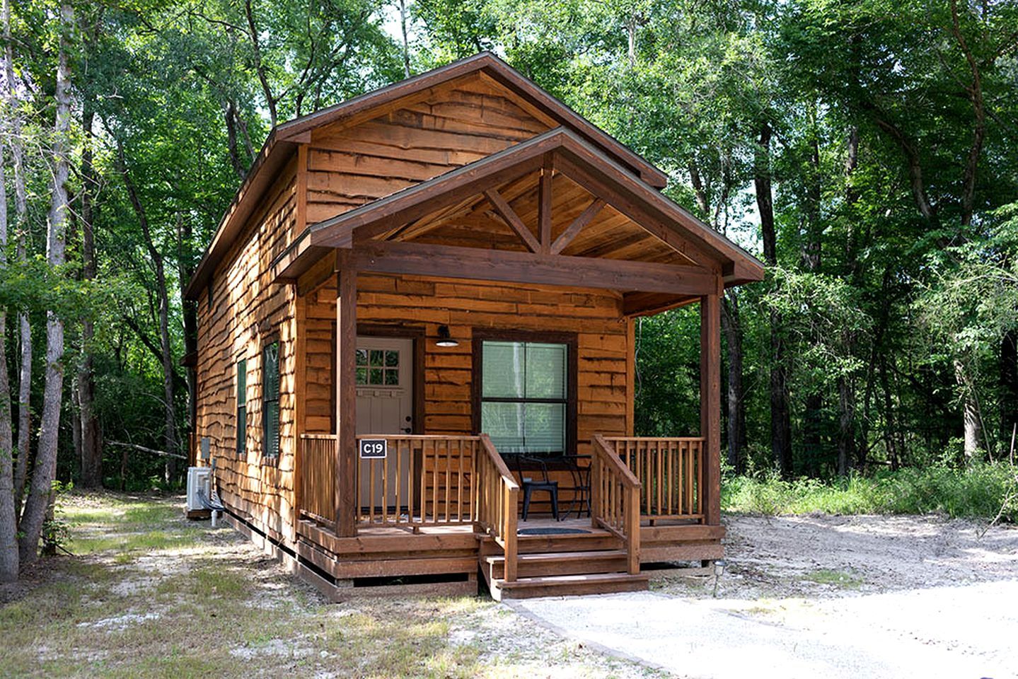 Eine Holzhütte mit Veranda, einer Tür und einem Fenster.