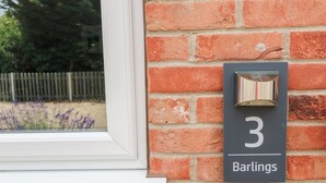 Un mur de briques portant le numéro «  3 » et le nom « Barlings », indiquant une propriété ou un lieu.
