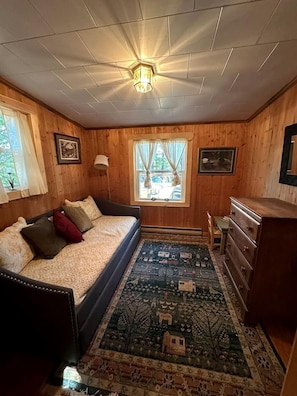 Ein gemütliches Zimmer mit Bett, Schminktisch und Fenster mit Vorhängen.