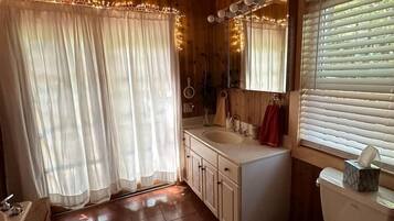 Un baño con inodoro, lavabo y espejo.
