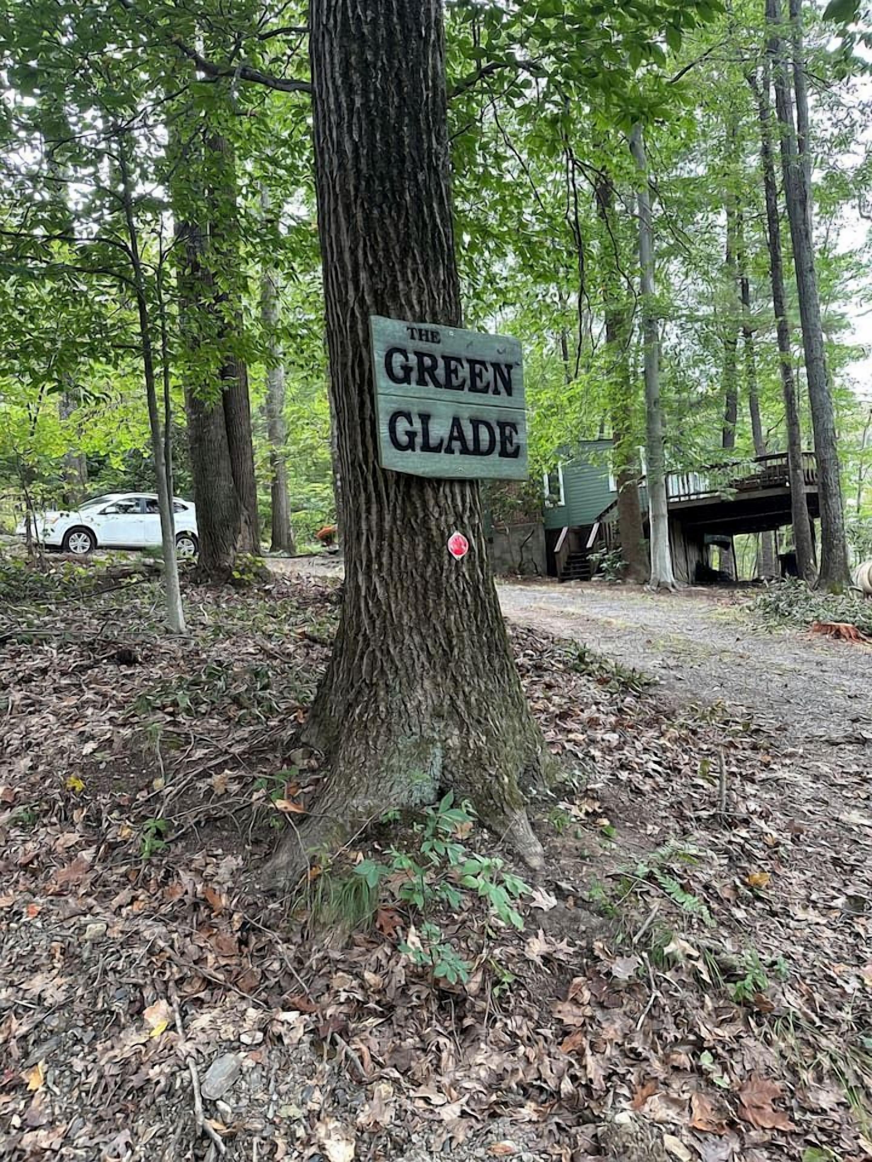 Un arbre sur lequel est fixée une pancarte indiquant « Clairière verte ».