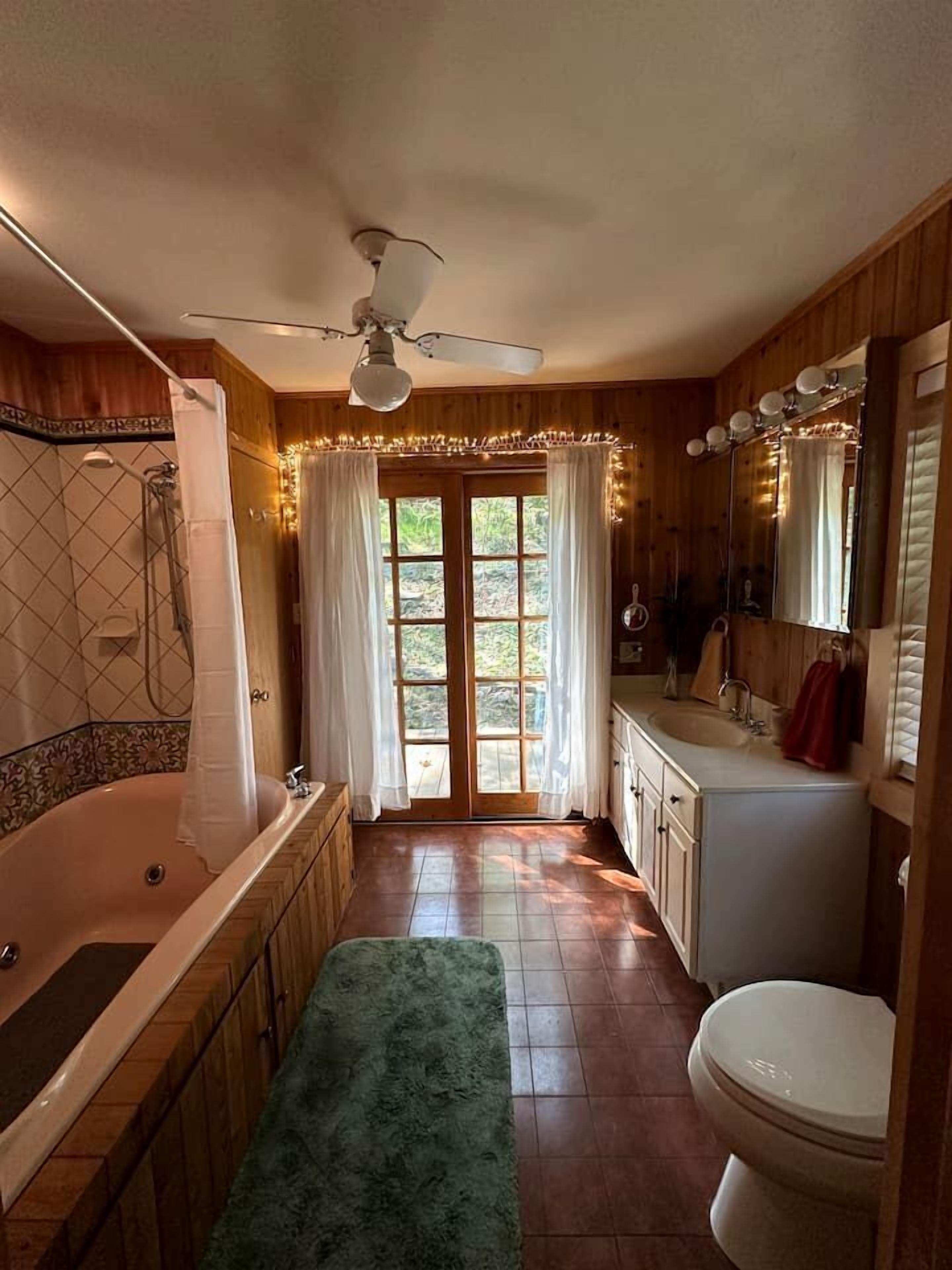 Une salle de bain équipée d’une baignoire, de toilettes, d’un lavabo et d’une douche.