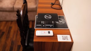 A wooden desk with a black tray, a white electronic device, and a QR code. - Z Cafe and Apartment (Kathmandu)