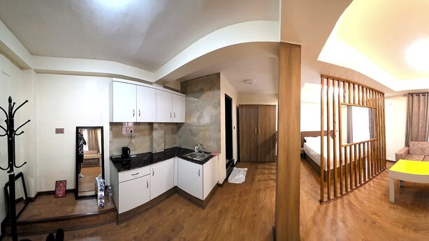 A compact living space with a kitchenette, a dining area, and a bedroom. - Z Cafe and Apartment (Kathmandu)