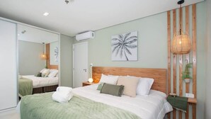 Un dormitorio con una cama grande, cabecera de madera, planta en la pared y ventilador de techo.