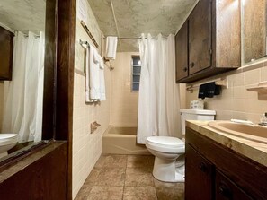 Une salle de bain avec une baignoire, des toilettes et un lavabo.