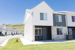 A modern two-story residential building with a front porch, a fire hydrant, and a clear sky. - Teal Waters - close to downtown! (Garden City)