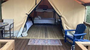 Eine Zelthütte mit Etagenbett, kleinem Tisch und Stuhl.