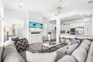 A modern living room with a sofa, coffee table, and a painting of a beach scene. - Le Destin Gulf Views Private Pool Private Beach (Miramar Beach)