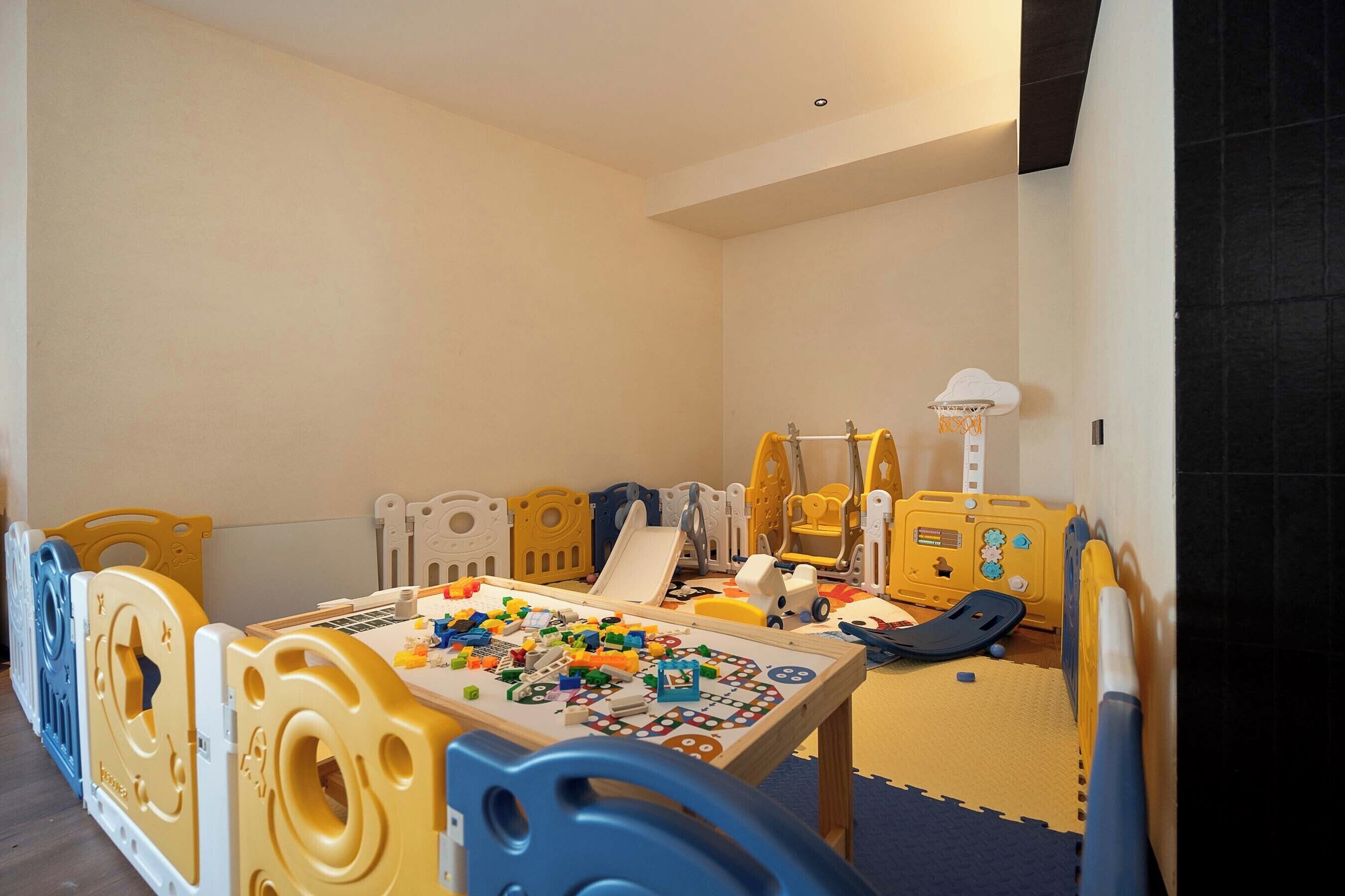 A play area with a table, toys, and play structures.