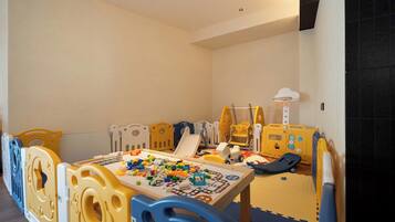 A play area with a table, toys, and play structures.