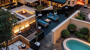A hotel courtyard with outdoor seating, a pool, and snow-covered mountains in the background. - Qinghe Courtyard Jiuzhaigou (Ngawa Autonomous Prefecture)