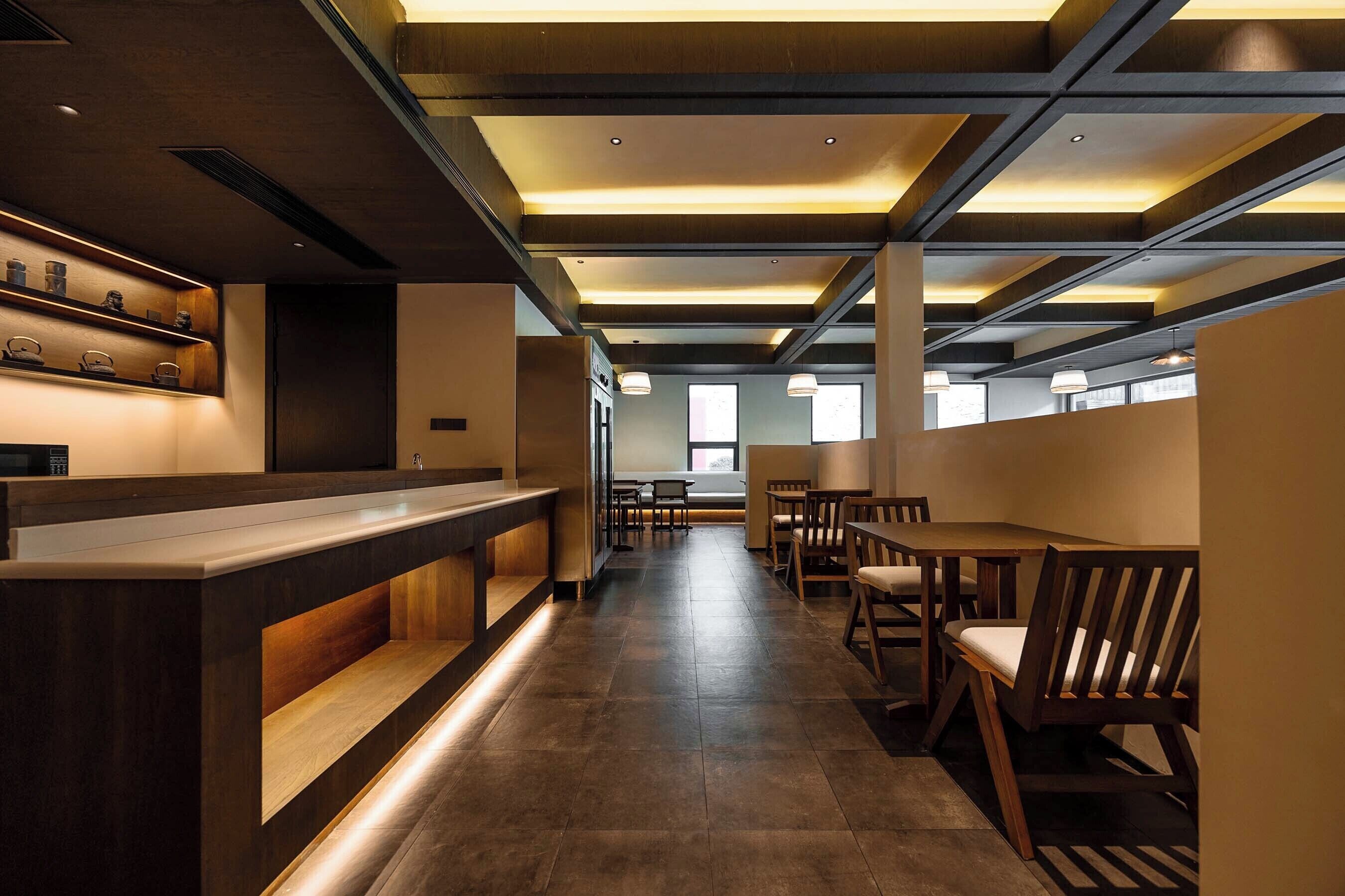 A modern interior with a reception desk, seating area, and large windows.