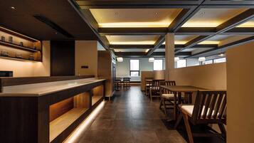 A modern interior with a reception desk, seating area, and large windows.