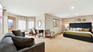 A bedroom with a large bed, a sofa, a desk, and a chair. - Luxurious Retreat with Expansive Yard in Sister Bay, Wisconsin (Sister Bay)