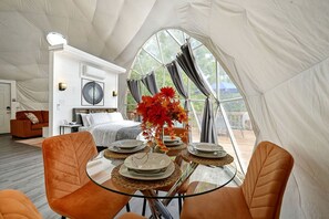 A tented accommodation with a dining area, a bedroom, and a living space.
