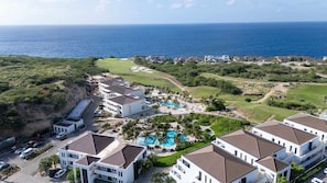 A resort with multiple buildings, a swimming pool, and a view of the ocean. - Florijn 7 Ocean View Penthouse at The Reef (Sint Michiel)