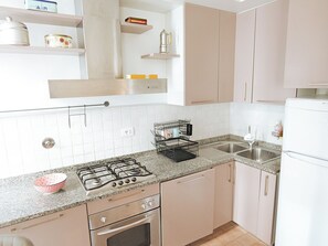 A kitchen with a gas stove, oven, sink, and cabinets. - Filukki Holiday Home, your comfortable and elegant apartment for enjoying Florence (Firenze)