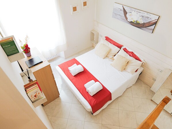 A neatly arranged hotel room with a bed, a desk, a chair, and a window. - Filukki Holiday Home, your comfortable and elegant apartment for enjoying Florence (Firenze)