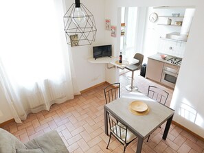 A modern kitchen with a dining area, a TV, and a pendant light. - Filukki Holiday Home, your comfortable and elegant apartment for enjoying Florence (Firenze)