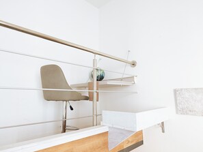 A modern, minimalist room with a white wall, a wooden desk, a metal-framed chair, and a small shelf with a globe. - Filukki Holiday Home, your comfortable and elegant apartment for enjoying Florence (Firenze)