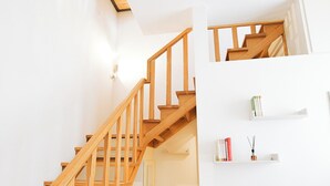 Eine Holztreppe mit einer Glastür am Fuß.