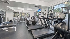 A gym with treadmills, exercise bikes, and weight machines.