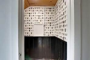Ein Zimmer mit strukturiertem Wandpapier, einem weißen Schrank und einer dunklen Holztür.