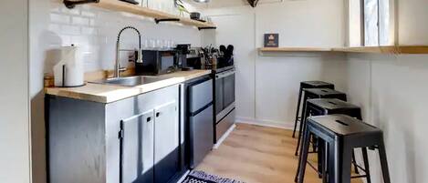A modern kitchen with a central island, built-in appliances, and a hanging bull's head decoration.