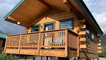 Une cabane en bois dotée d’un balcon, d’un toit à deux versants et d’une fenêtre.