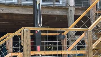 A wooden staircase with a metal railing leading to a second-floor balcony.