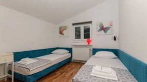 A small, clean room with two single beds, a desk, and a window. - Villa Mili by Villas Guide (Nova Sela)