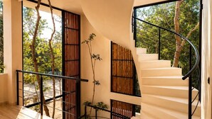 A modern interior with a spiral staircase, wooden flooring, and large windows allowing natural light. - Villa Lumila Rooftop Sunset & Jungle Views (Tulum)