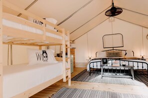 A bunk bed room with a desk, a hanging light fixture, and a patterned rug. - Luxury Glamping by Lake Blackshear: Cozy Safari Tent in Cordele, Georgia (Cordele)