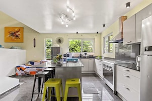 A modern kitchen with a central island, stainless steel appliances, and a window providing natural light.