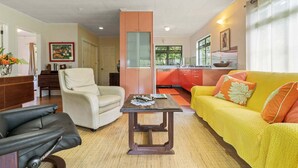 A living room with a sofa, armchair, and a coffee table. - Peaceful 2BR Garden Bungalow (Taiarapu-Est)