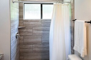 A shower with a window, a towel rack, and a toilet. - Perfect Cabin Retreat for Four in Livingston, Texas (Livingston)