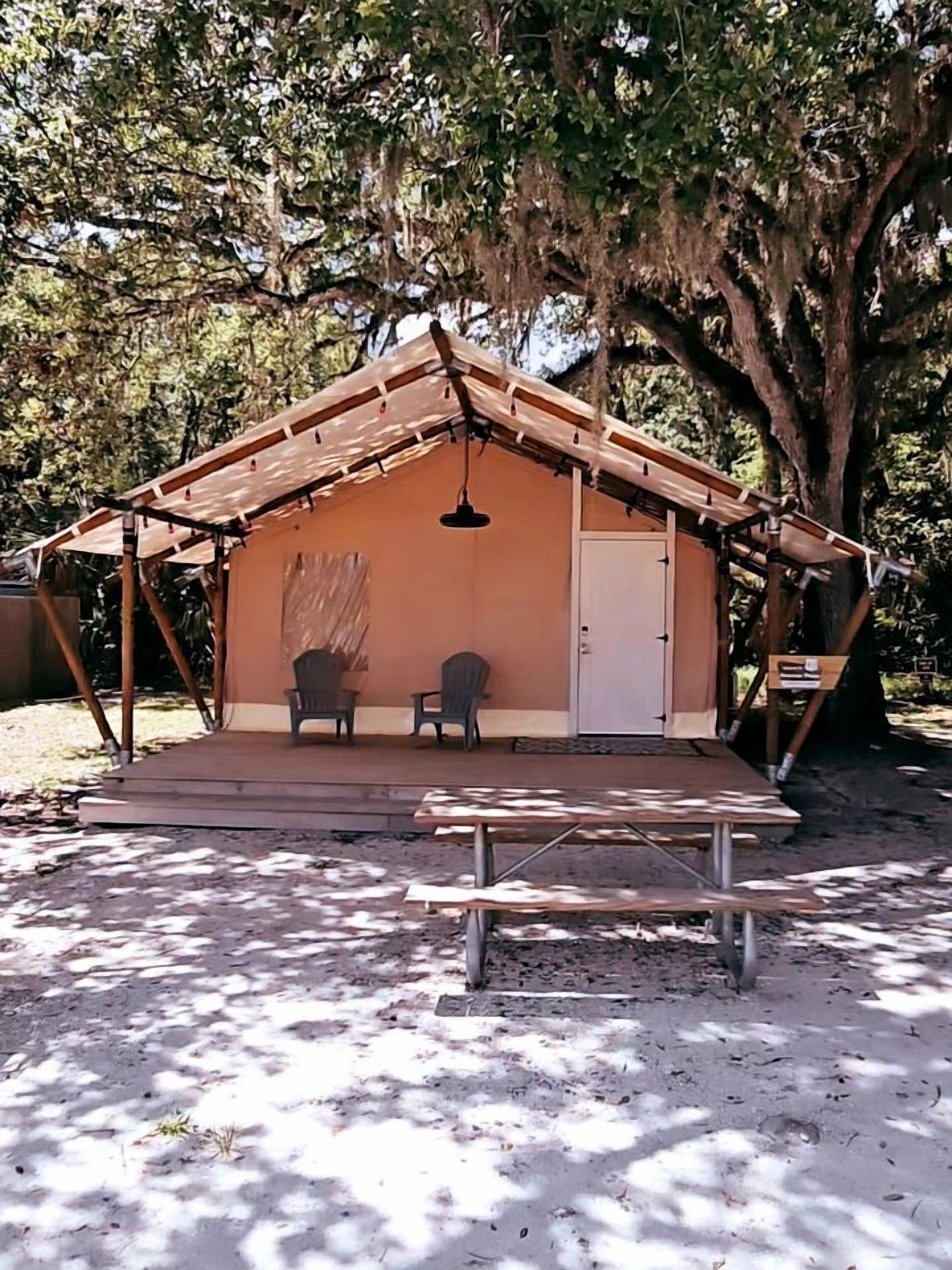A small, single-room structure with a pitched roof, a door, and a bench outside.