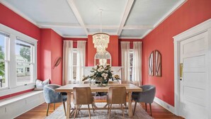 A dining room with a table, chairs, a chandelier, and a window with curtains. - The Veranda at Wares Creek - Sleeps 12, Pet-friendly, minutes to Gulf beaches! (Bradenton)