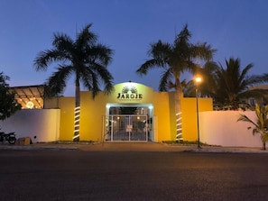 Un edificio con un letrero que dice 'JAROE' y una entrada protegida por una reja.